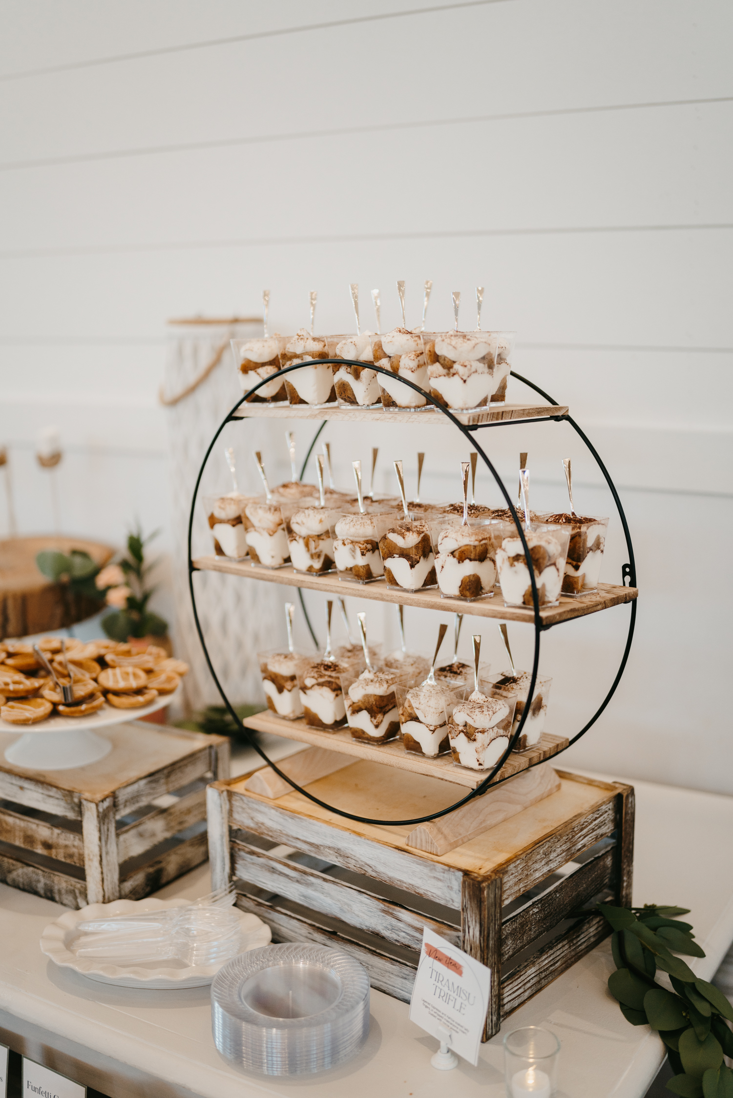 Tiramisu Trifle Display Tiramisu trifle elegantly displayed on a circular shelf as part of a beautifully decorated dessert table with stylish decor.