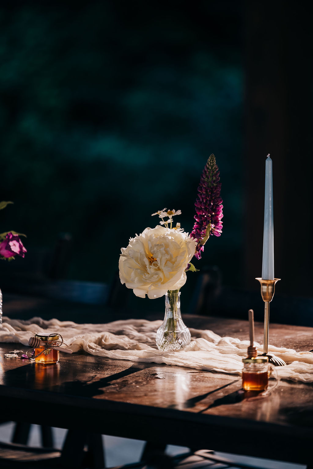 Reception table details Elegant wedding table with single-stem florals, tapered candle, and honey jar wedding favors.