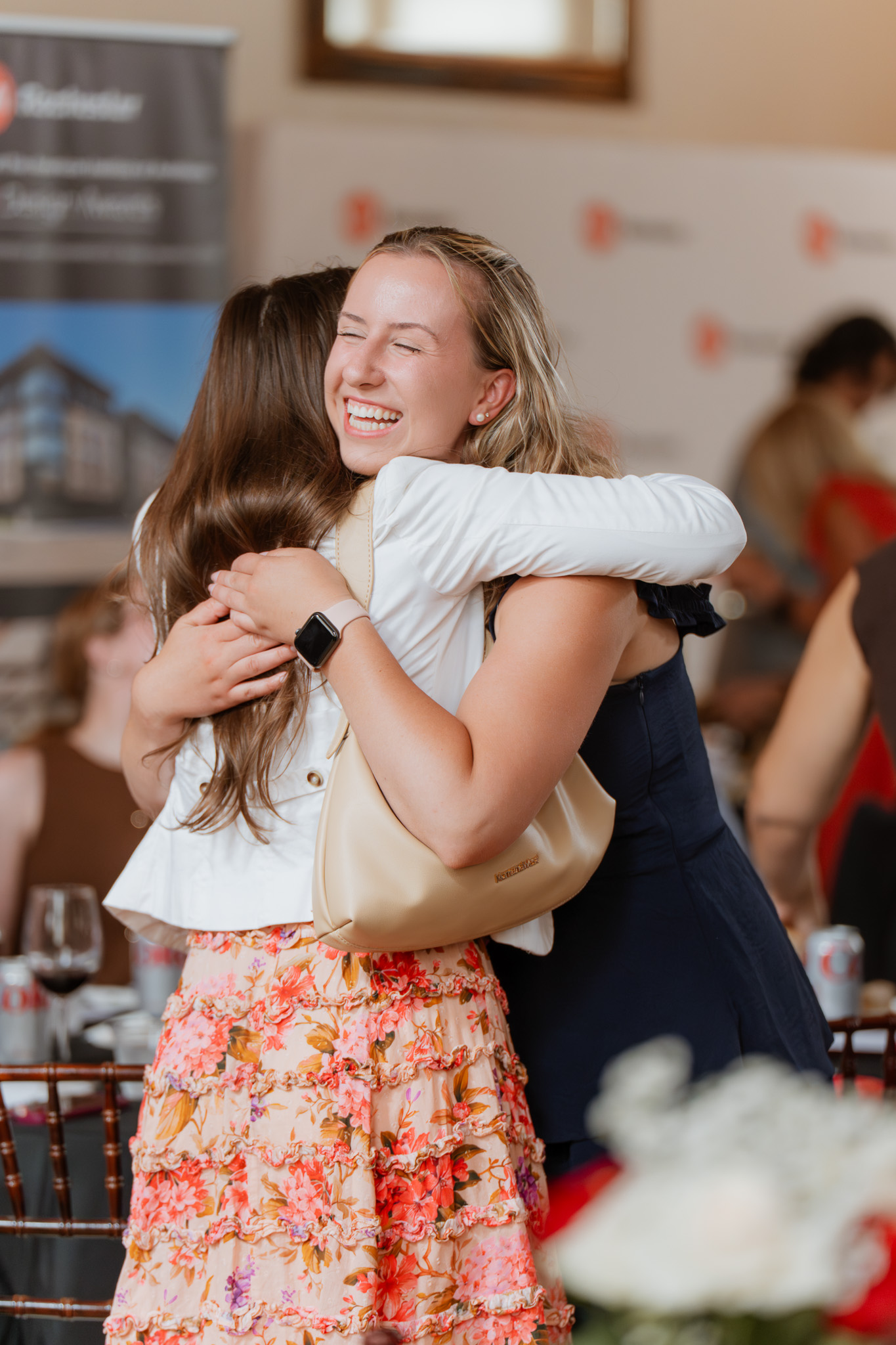Guests Greeting One Another at Corporate Networking Event at The Historic German House Two guests share a warm hug during a networking reception at The Historic German House in Rochester, NY, creating a welcoming atmosphere for attendees.