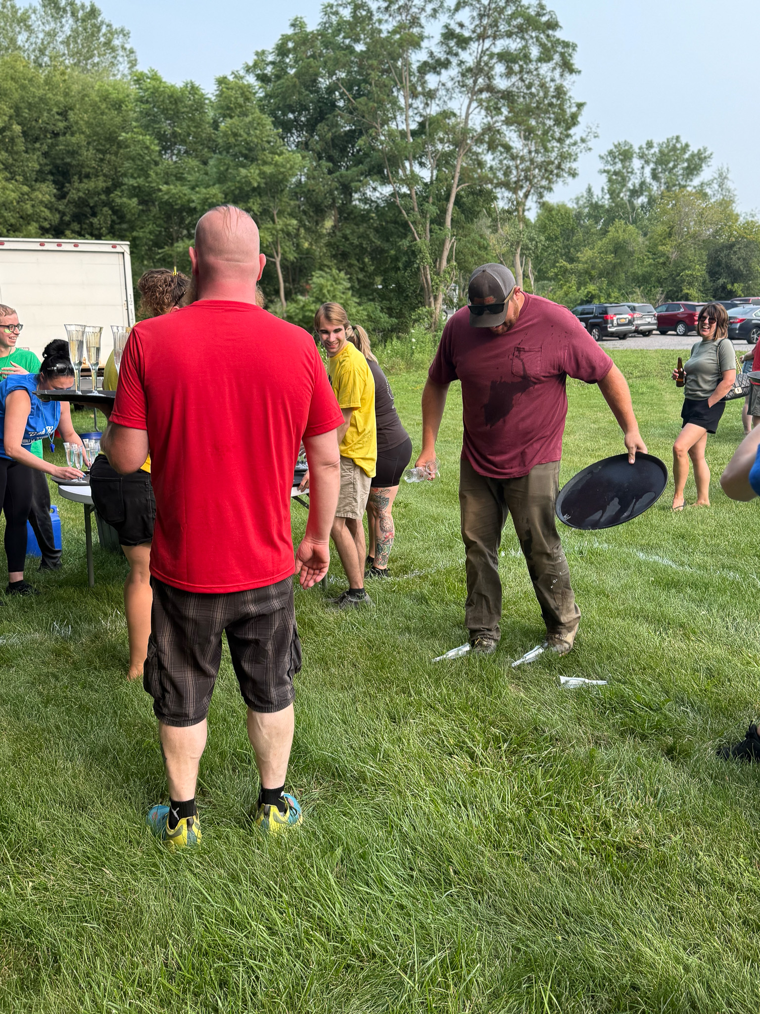 Last Call Catering Tray Gauntlet | Funner Olympics 2026 Partyman team members compete in Last Call: The Catering Tray Gauntlet, balancing serving trays and champagne glasses during the 2026 Funner Olympics.