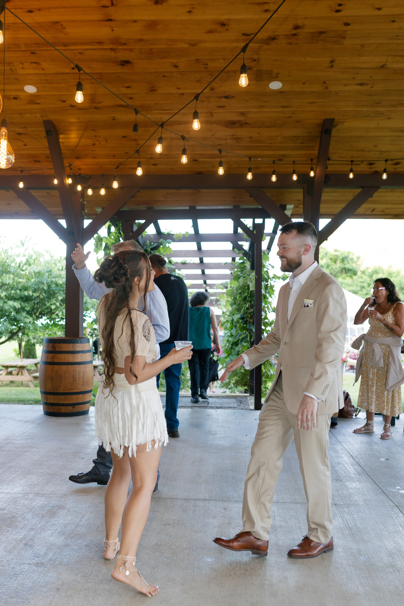 Candid Wedding Reception Dancing | Inspire Moore Winery Wedding guests dancing beneath warm string lights in the open-air reception space at Inspire Moore Winery & Vineyard.