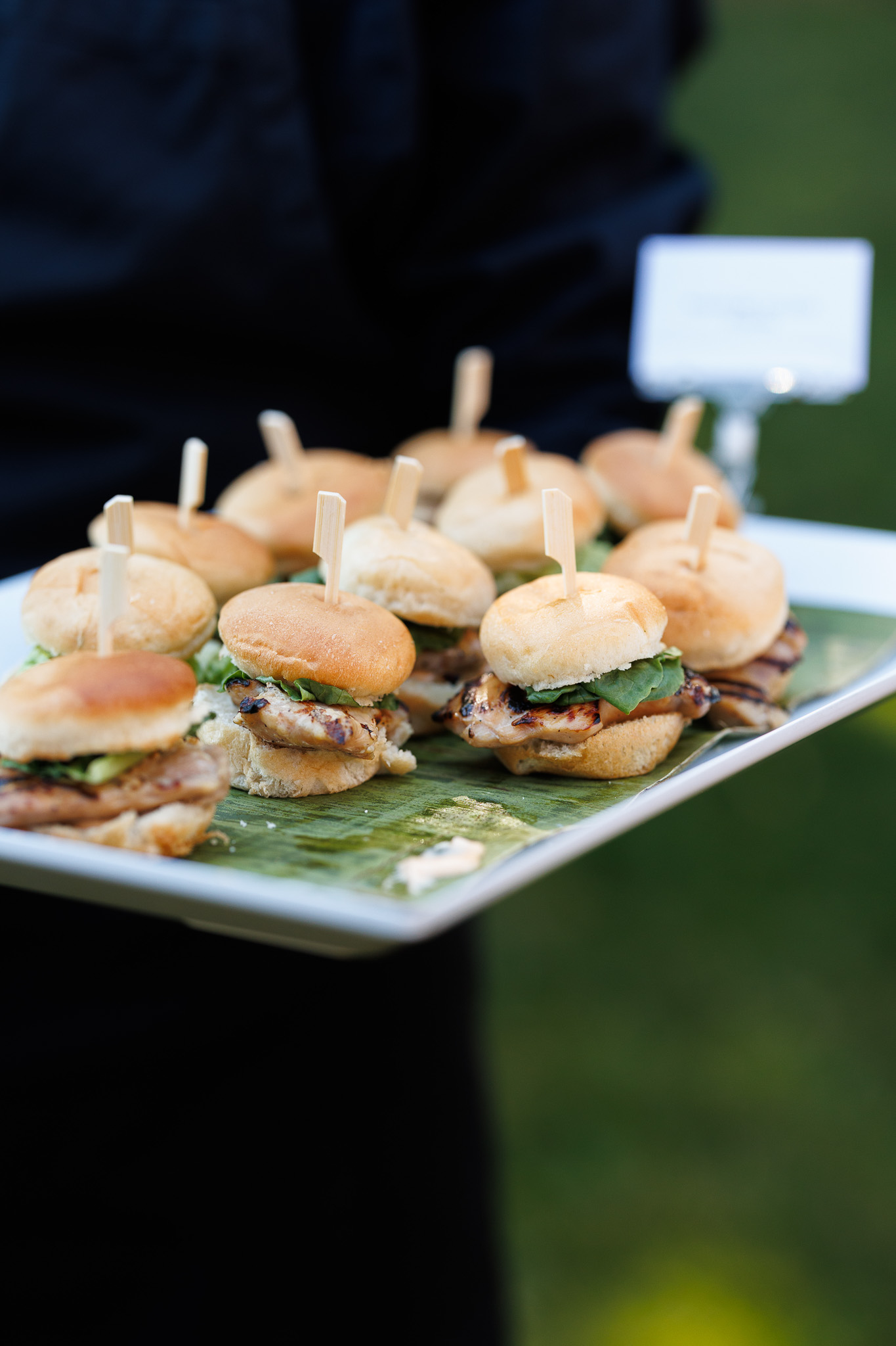 Handpassed Chicken Sliders | Wedding Cocktail Hour Catering Tray of grilled chicken sliders with fresh greens served as handpassed appetizers during cocktail hour by Partyman Catering.